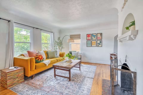 Living room with mustard sofa and fireplace.