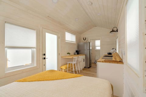 Bed and compact kitchen with front entry.