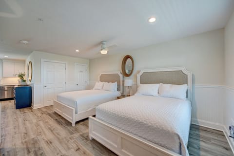 Sink into crisp white linens in your spacious twin bedroom, where coastal comfort meets modern style with elegant furnishings and peaceful vibes.
