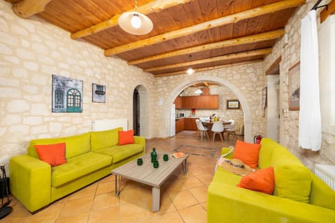 Open-plan living room with sofas, dining area, kitchen, ornamental fireplace, A/C, WiFi internet, and satellite TV