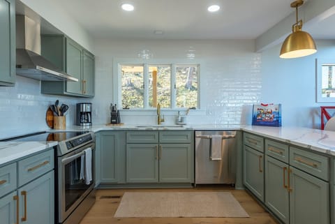 The sleek & newly updated kitchen offers island seating for 3, a dishwasher, and a Drip-style coffeemaker.