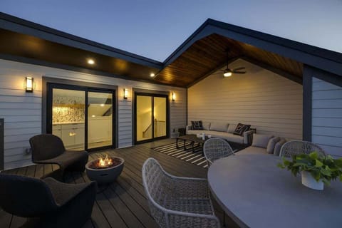 Upper Unit - 4th Floor: Private partially covered rooftop deck offering stunning city-skyline views and diverse outdoor furnishings for lounging and dining including a fire pit.