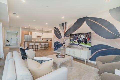 Unit 1: Bright open living space featuring Samsung Frame Smart TV, designer furnishings, and access to private patio.