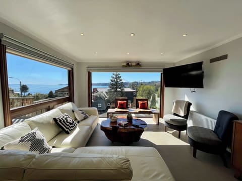 Bright living area w/ plush seating & large windows framing scenic water views
