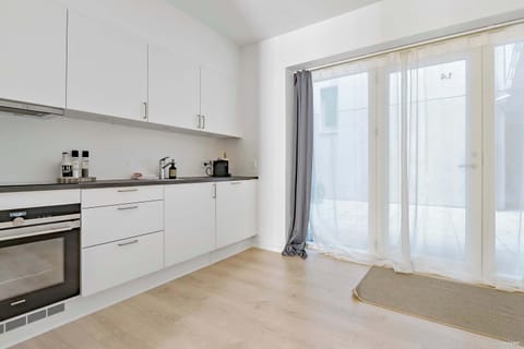 Kitchen and entrance to the apartment with double-curtains (Thin curtains and blackout curtains). The entrance-area outside is fully private and can only be accessed by residents of the property.