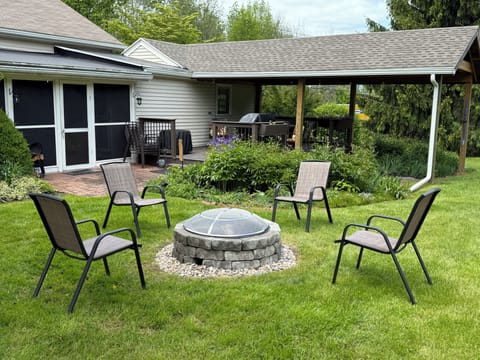 Relax and unwind in the spacious backyard with a covered deck, screened-in porch, and cozy fire pit—perfect for memorable outdoor gatherings.