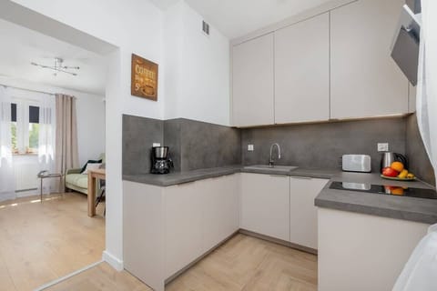 A compact yet fully equipped kitchen with sleek appliances and upper cabinets. The layout is efficient and clean, great for short- or long-term stays.
