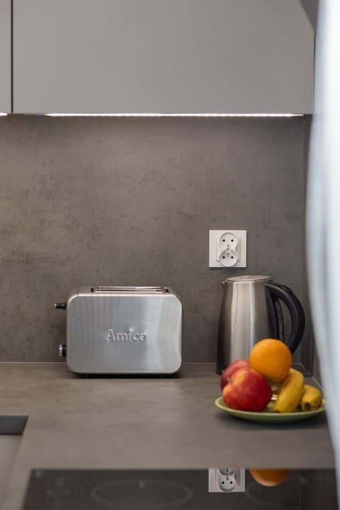 A detail shot of a sleek black toaster placed on a modern kitchen counter.