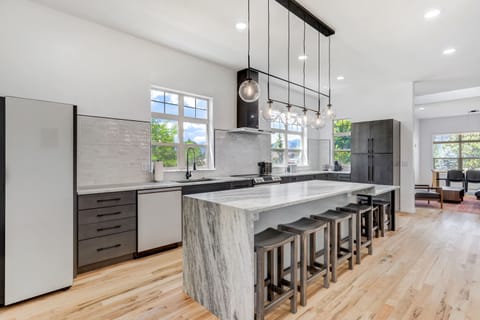 Modern kitchen features a large island, stainless steel appliances, and ample counter space, perfect for cooking and entertaining.