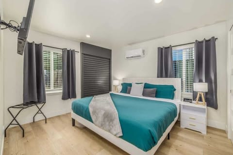 King sized bed with tv, lighted night stands with wireless phone chargers, luggage rack and blackout curtains 