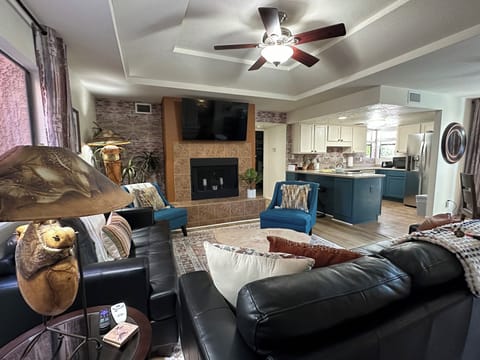 Open living room with large smart tv, leather sofa and southwest touches