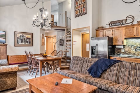 Main Living Space: Open layout, kitchen, living room and dining room, floor-to-ceiling stone mantle, ample natural light