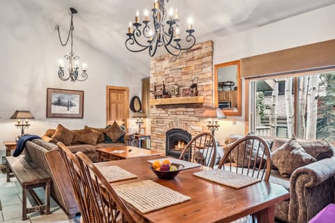 Main Living Space: Open layout, kitchen, living room and dining room, floor-to-ceiling stone mantle, ample natural light