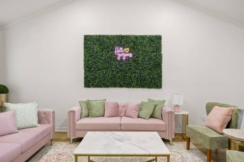 Gather in style—this chic living room features plush seating, bold pops of color, and a playful “Hello Gorgeous” neon wall, perfect for group photos, conversations, or simply relaxing in comfort.  Perfect for Instagram photos!