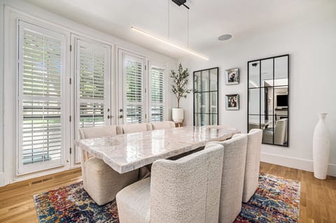 - Host elegant dinners at this chic marble dining table surrounded by plush seating
- Floor to ceiling windows with plantation shutters brighten the space with natural light
- Decorative accents and wall art add warmth and character


