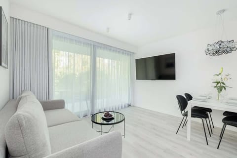 Bright living room with large windows and soft decor
Modern and cozy space with natural light, stylish furniture, and a tranquil view.