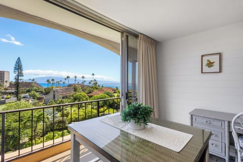 Stunning ocean and mountain views stretch before you from this sunny balcony, framed by swaying palms and lush tropical greenery—your perfect spot to unwind.