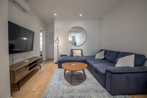 📺 Modern Luxury: Expansive living area with a large flat-screen TV and premium sectional sofa.