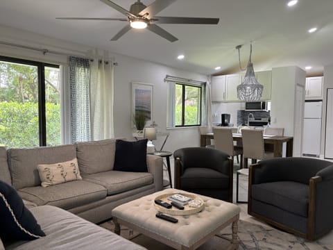 Our large, open living room has seating for six in front of the TV. Two large sliding glass doors let in plenty of light and views of the surrounding, peaceful landscaping.
