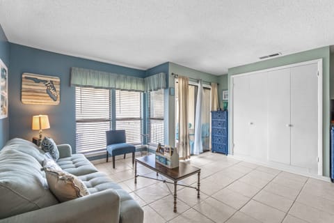 Unwind in your coastal-themed living room with plush seating, natural light, and beach-inspired décor creating the perfect vacation atmosphere.