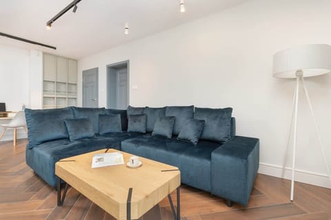 Living Room – Spacious open-plan living area with a dark blue sectional sofa and modern decor.

