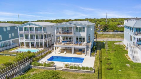 Stunning beachside property featuring private pool and spacious outdoor areas, surrounded by natural coastal landscape and neighboring vacation homes.