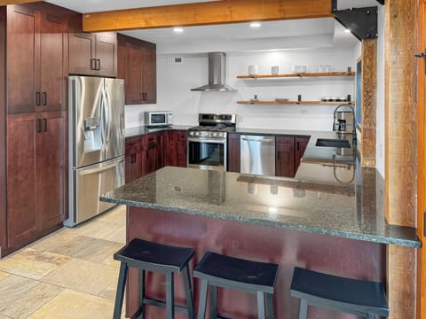 New appliances in kitchen includes oversized refrigerator. 