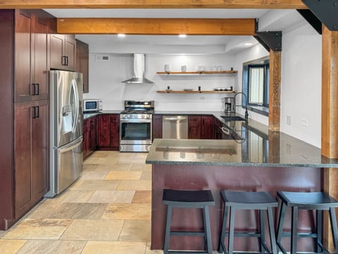 Newly remodeled kitchen has two dishwashers, gas range and hood. Seating for 3.