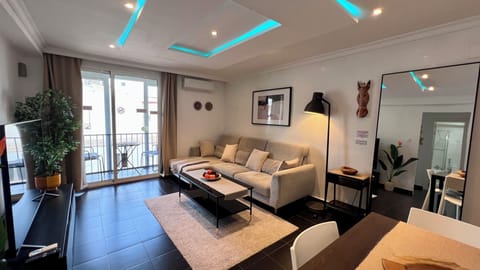 Bright modern lounge with balcony, sectional sofa, and stylish LED ceiling