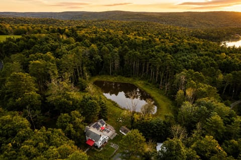 Mountain views and sunset skies frame this secluded Catskills retreat. Your private waterfront pond and dense forest surroundings offer a peaceful setting for wildlife sightings.