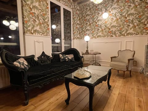 Elegant seating area with Art Deco furniture and vintage wallpaper in a city center Brussels apartment.