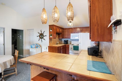 The tiled countertops extend to a breakfast bar with seating.