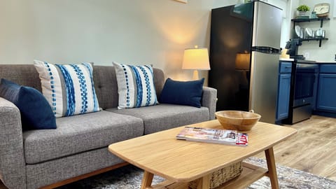 The cozy living room in the Little House is such a warm and inviting space created by a comfortable sofa with plump pillows and a soft throw, perfect for lounging and reading a book. Overall, it's the perfect spot to relax and unwind after a long day.