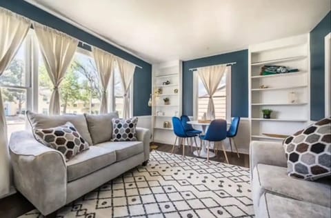 The upstairs living room with two comfy couches, smart TV, AC unit, dining table