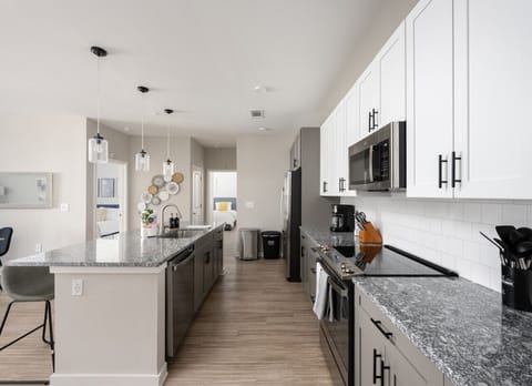 Welcome to our open kitchen! Fully equipped with sleek stainless steel appliances and ample counter space, it`s perfect for cooking and quick meals.