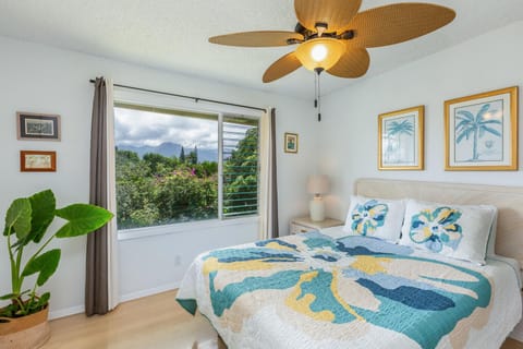 The second bedroom has incredible views of Kauai's mountainous interior, and features the same jalousie windows to keep breezes flowing through the whole house