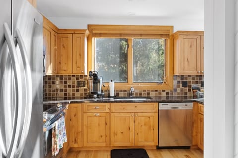 - Modern rustic kitchen with stainless steel appliances and forest views   - Warm wood cabinetry adds cozy lodge-style charm and character   - Perfectly designed for preparing hearty mountain-inspired meals