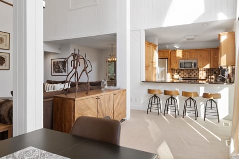 - Open-concept layout blending rustic charm with modern kitchen style   - Four bar stools and cozy seating ideal for shared mountain meals   - Large windows brighten the space with natural alpine light