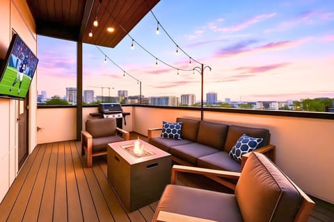 The rooftop terrace glows at golden hour with Nashville city views and plush outdoor seating.