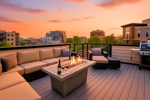 Rooftop deck at sunset with fire pit table, outdoor sectional sofas, and Nashville city skyline views