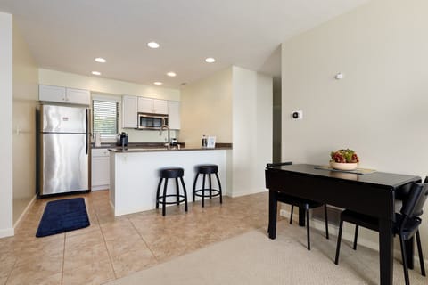 Dining area w/ a sleek table set beside the open kitchen for easy gatherings.