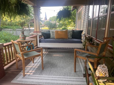 side deck with twin size swingbed overlooking the lush gardens