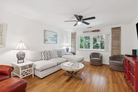 Living area boasts cozy modern furnishings, smart TV for movie nights or watching a game, ceiling fans for added ambiance