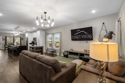 Open Concept Living Room with 65" 4K Flat Screen & Queen Fold Out Mattress (1)