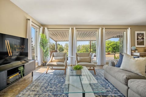 Main floor living room with cozy seating, a 55` Roku TV & access to the outdoor deck/backyard/patio space.