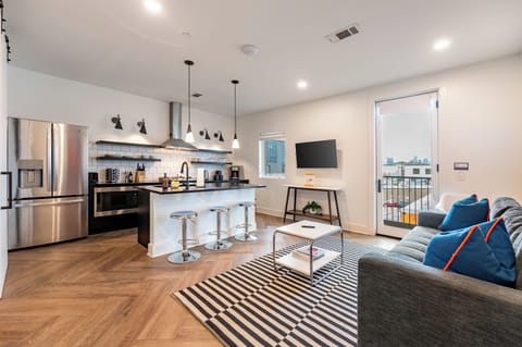 Sleek open-concept living with a modern kitchen and city views.