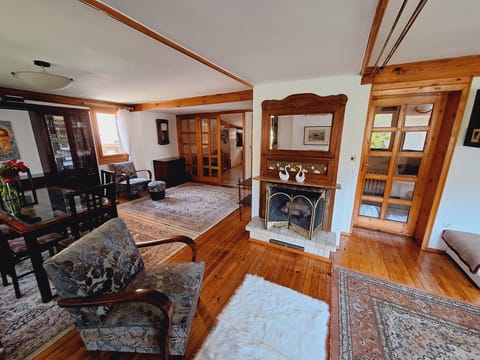 Spacious open-concept living & dining room space with decorative fireplace.
