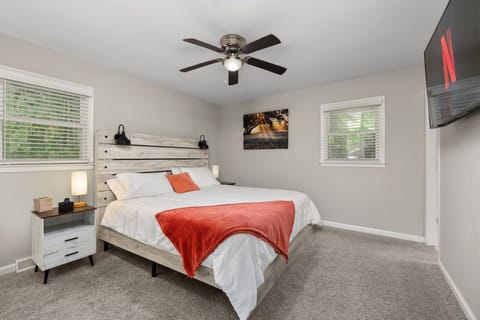 Cozy, light-filled bedroom with TV, ceiling fan, and rustic modern style