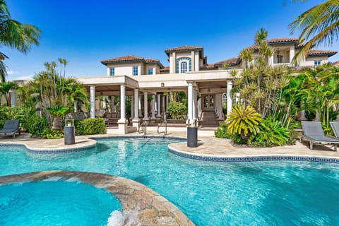 - Mediterranean-style villa surrounded by lush tropical landscaping, featuring an elegant pool for ultimate relaxation - Elegant outdoor space with classical columns and shaded lounge areas - Ideal retreat blending comfort, and serene natural beauty