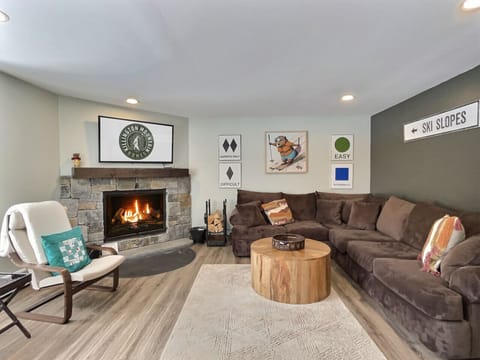 Relax in the inviting living room with a super comfortable couch and a wood-burning fireplace, perfect for cozy evenings.